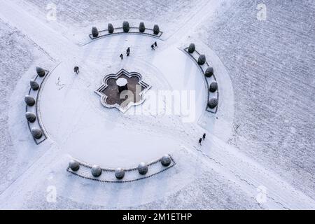 Oranienbaum, Allemagne. 12th décembre 2022. Les passants traversent à pied le parc enneigé du château d'Oranienbaum (vue aérienne avec drone). Construit en 1683 comme résidence d'été pour la princesse Henriette Catharina, épouse du prince Johann Georg II d'Anhalt-Dessau et princesse d'Orange-Nassau de naissance, le palais a été rénové morceau par morceau depuis des années. Avec son magnifique jardin, il fait partie du Royaume des jardins de Dessau-Wörlitz, site classé au patrimoine mondial de l'UNESCO. Credit: Jan Woitas/dpa/Alay Live News Banque D'Images