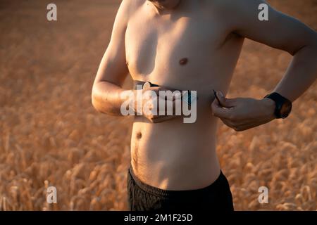 L'homme porte un moniteur de fréquence cardiaque avant sa course et son entraînement par jogging. Banque D'Images