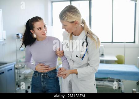 Gros plan d'un médecin aidant une adolescente malade dans son bureau d'ambulance. Banque D'Images