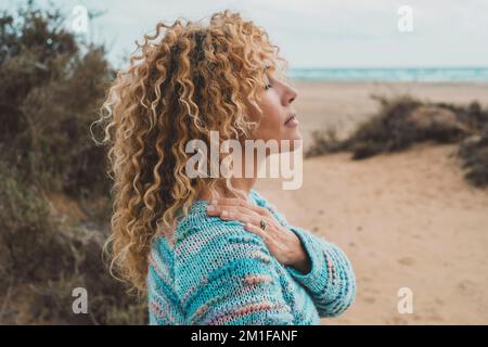 Une femme aime l'équilibre intérieur et la méditation loisir activité de plein air seul sentant la nature se embrassant à la plage. Portrait latéral de zen lifesyl Banque D'Images