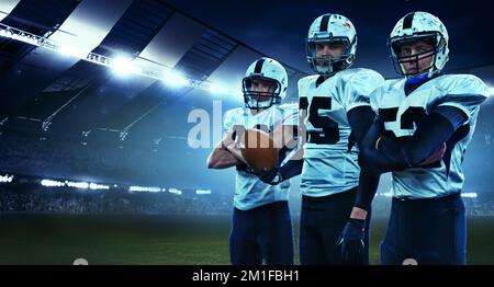 Coéquipiers. Trois athlètes américains de football, des sportifs debout en uniforme isolés au stade avec des flashs. Concept de sport, défis Banque D'Images