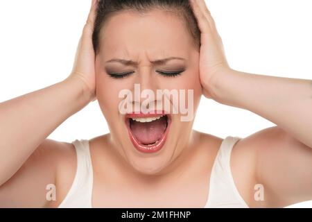 Photo de la jeune femme bouleversée couvre les paumes oreilles bruit fort cri isolé sur fond blanc studio Banque D'Images