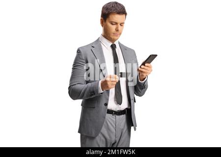 Jeune homme professionnel tenant un smartphone et regardant une carte de crédit isolée sur fond blanc Banque D'Images