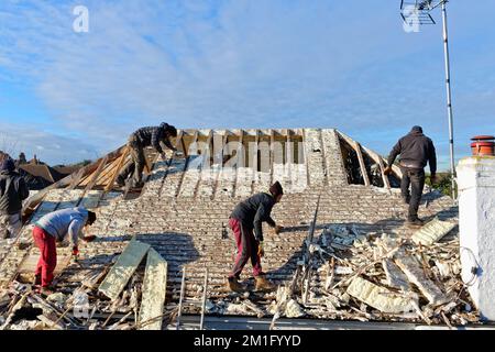 Les constructeurs retirent l'isolation en mousse pulvérisée durcie de l'espace de toit d'une maison privée de banlieue, Shepperton Surrey, Angleterre, Royaume-Uni Banque D'Images