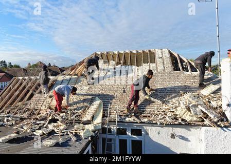 Les constructeurs retirent l'isolation en mousse pulvérisée durcie de l'espace de toit d'une maison privée de banlieue, Shepperton Surrey, Angleterre, Royaume-Uni Banque D'Images