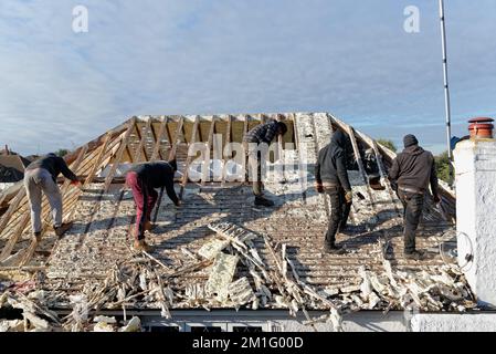 Les constructeurs retirent l'isolation en mousse pulvérisée durcie de l'espace de toit d'une maison privée de banlieue, Shepperton Surrey, Angleterre, Royaume-Uni Banque D'Images