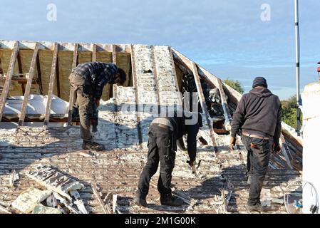 Les constructeurs retirent l'isolation en mousse pulvérisée durcie de l'espace de toit d'une maison privée de banlieue, Shepperton Surrey, Angleterre, Royaume-Uni Banque D'Images