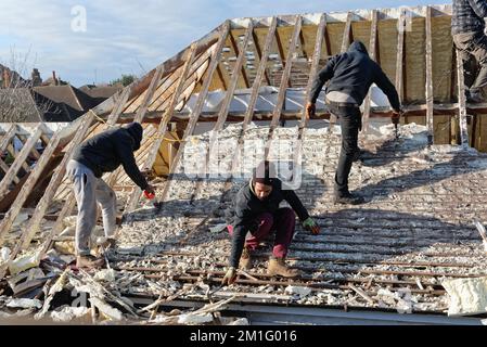 Les constructeurs retirent l'isolation en mousse pulvérisée durcie de l'espace de toit d'une maison privée de banlieue, Shepperton Surrey, Angleterre, Royaume-Uni Banque D'Images