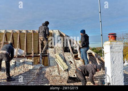 Les constructeurs retirent l'isolation en mousse pulvérisée durcie de l'espace de toit d'une maison privée de banlieue, Shepperton Surrey, Angleterre, Royaume-Uni Banque D'Images