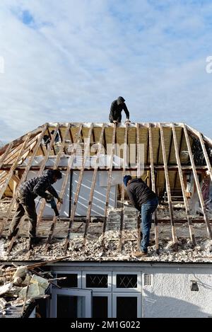 Les constructeurs retirent l'isolation en mousse pulvérisée durcie de l'espace de toit d'une maison privée de banlieue, Shepperton Surrey, Angleterre, Royaume-Uni Banque D'Images