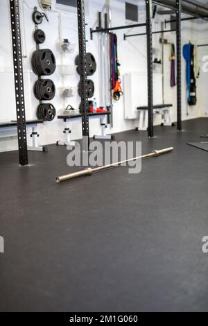Vue en grand angle de la tringle de musculation en argent métallique située sur un sol noir dans le centre de fitness Banque D'Images