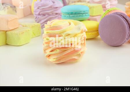 Divers bonbons : macarons, guimauves et zéphans. Desserts colorés délicats pour le présent. Banque D'Images