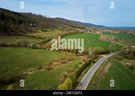 Vol de drone au-dessus du village de montagne parmi les champs agricoles verts, vue sur la campagne, paysage de la nature Banque D'Images