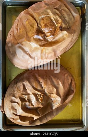 Une grande citrouille au fromage coupée en deux et fraîche du four pour faire du pain de citrouille et de la tarte à la citrouille. Banque D'Images