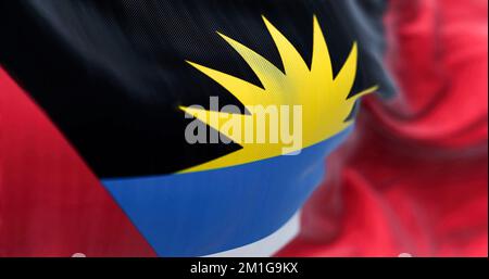 Vue rapprochée du drapeau national d'Antigua-et-Barbuda. Antigua-et-Barbuda est un État insulaire d'Amérique centrale. Arrière-plan texturé en tissu. Banque D'Images