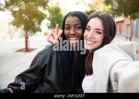 Deux jeunes amis multiculturels qui prennent le selfie et s'amusent ensemble - blancs et Afro-américaines filles qui s'amusent ensemble. Banque D'Images