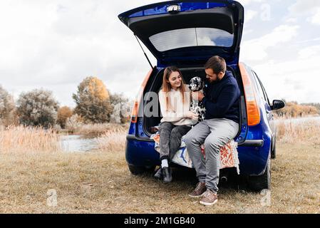 Un jeune couple s'amuse avec un chien dalmate en plein air. Banque D'Images