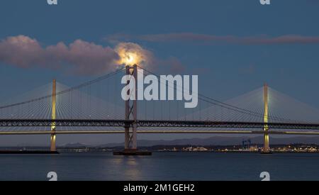 Une pleine lune se couche sur Queensferry Crossing et Forth Road ponts à l'heure bleue, Firth of Forth, Écosse, Royaume-Uni Banque D'Images