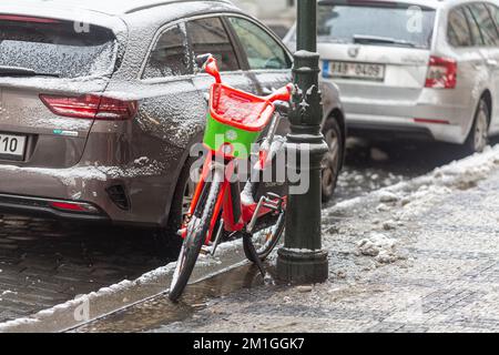 PRAGUE, République Tchèque – 12th 2022 DÉCEMBRE : sur un vélo de ville et Uber garés dans une rue, par temps de neige en hiver Banque D'Images