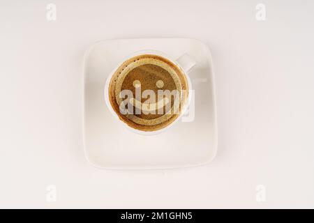 Tasse à café avec visage souriant en mousse. Le concept de joie. Banque D'Images