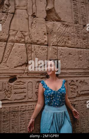 Photo verticale d'une jeune touriste femelle se posant près d'une pyramide historique en Égypte Banque D'Images