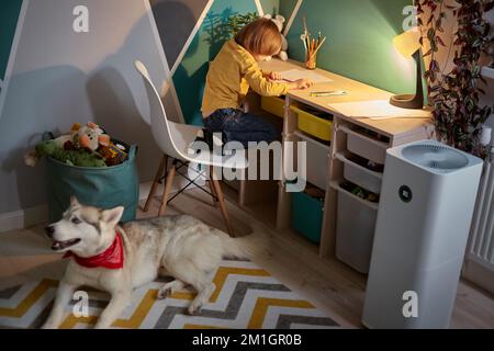 Purificateur d'air dans la chambre des enfants avec un enfant allergique et un chien Banque D'Images