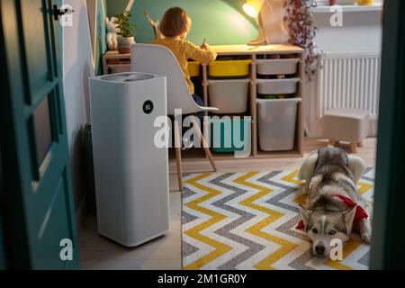 Purificateur d'air dans la chambre des enfants avec un enfant allergique et un chien Banque D'Images