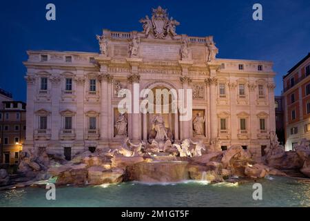 Une vue complète sur la fontaine de Trevi en face du Palazzo poli, chaleureusement éclairé par les lumières juste avant le lever du soleil. Banque D'Images