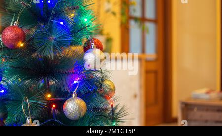 arbre de noël décoré de boules dorées et rouges et de lumières à del Banque D'Images