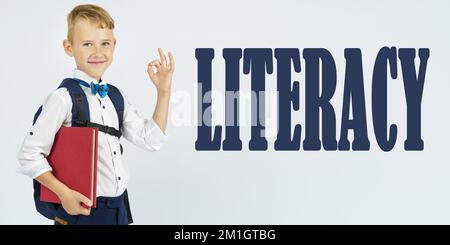 Concept d'éducation. Un écolier avec une mallette tient des livres dans ses mains et montre le geste ok. Le texte est écrit à côté - ALPHABÉTISATION Banque D'Images