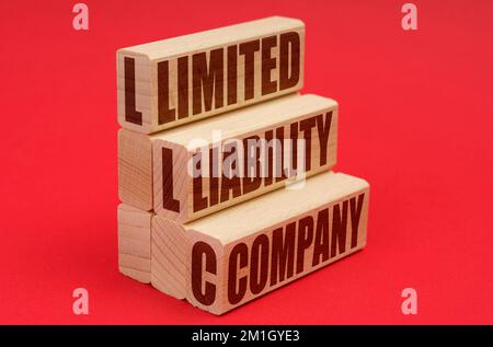 Concept d'affaires et d'économie. Sur fond rouge, des blocs de bois avec l'inscription - Limited Liability Company Banque D'Images