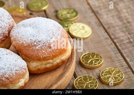 Bonne Hanoukkah. Beignets sucrés Hanukkah, boîtes-cadeaux, bougies blanches et pièces de chocolat sur fond de bois ancien. Image et concept de vacances juives Banque D'Images