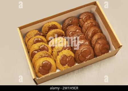 Une boîte en carton de livraison à domicile remplie de deux biscuits aux pépites de chocolat Banque D'Images