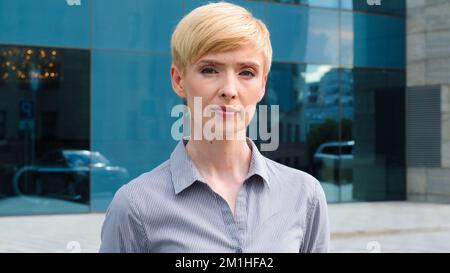 Gros plan femme sérieux visage portrait caucasien moyenne âge femme d'affaires patron blond court cheveux leader porte chemise formelle insatisfait expression Banque D'Images