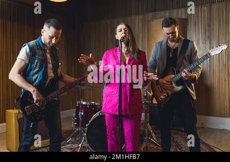 plan moyen-plein d'un groupe tout en répétant, concept de groupe de studio musical. Photo de haute qualité Banque D'Images