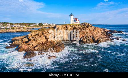 Immense île rocheuse avec phare sur la côte du Maine avec des vagues qui s'écrasant sur des rochers Banque D'Images