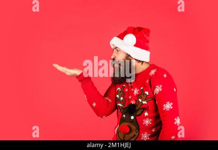 remises sur les achats de la nouvelle année. oh non homme mûr sur fond rouge de chandail. Fête de Noël. prêt pour des cadeaux et cadeaux de noël. père noël barbu Banque D'Images