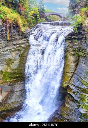 Grande chute d'eau dans le canyon avec pont d'arche en pierre en arrière-plan Banque D'Images