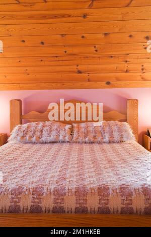 Cadre en bois lit double dans la chambre principale à l'intérieur de 1982 réplique construite de l'ancienne maison en bois rond de 1800s, Québec, Canada. Cette image est la propriété de calenda Banque D'Images