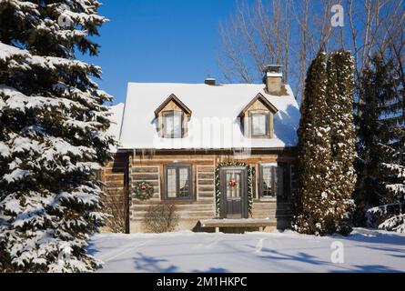 1982 réplique construite de 1800s Canadiana maison en rondins de deux étages avec décorations de Noël en hiver. Banque D'Images