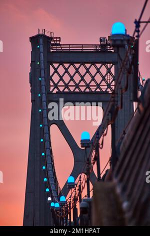 Lumières bleues en détail sur les fils de soutien de pont américain avec lumière dorée derrière Banque D'Images