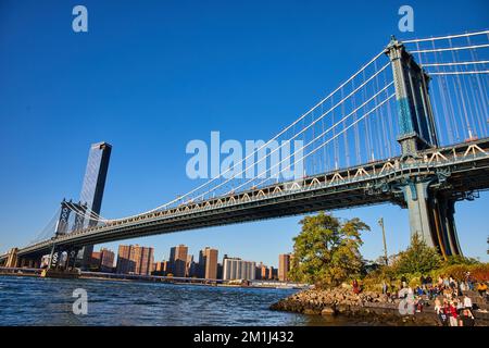 Vue de l'ensemble du pont de Brooklyn depuis un angle bas avec les eaux et la ville de New York en arrière-plan Banque D'Images
