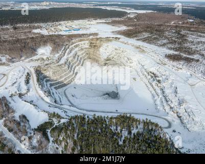 Vue aérienne de la carrière de pierre concassée en hiver avec de la neige. Exploitation de la pierre concassée en hiver. Banque D'Images