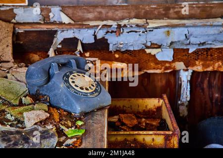 Téléphone rotatif vintage sur bureau abandonné en détail avec un mur en décades Banque D'Images