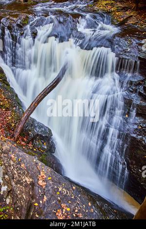 La rivière descend des gorges abruptes dans des rochers avec des feuilles d'automne Banque D'Images