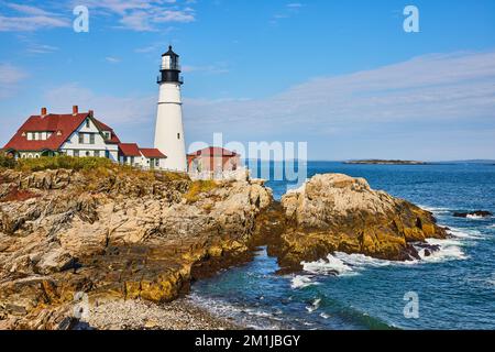 Magnifique phare blanc dans le Maine sur la côte rocheuse avec vagues de l'océan Banque D'Images