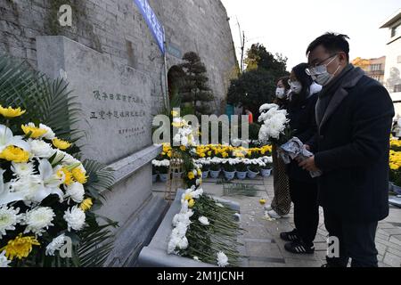 NANJING, CHINE - 13 DÉCEMBRE 2022 - les gens présentent des fleurs à un monument commémoratif pour les victimes du massacre de Nanjing par les envahisseurs japonais de Zhe Banque D'Images