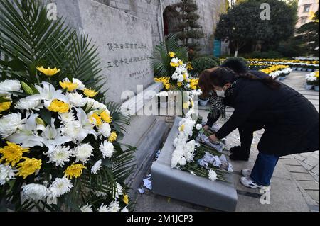 NANJING, CHINE - 13 DÉCEMBRE 2022 - les gens présentent des fleurs à un monument commémoratif pour les victimes du massacre de Nanjing par les envahisseurs japonais de Zhe Banque D'Images