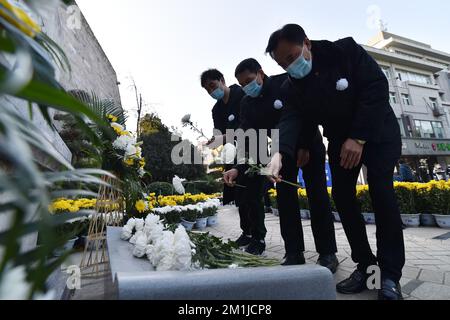 NANJING, CHINE - 13 DÉCEMBRE 2022 - les gens présentent des fleurs à un monument commémoratif pour les victimes du massacre de Nanjing par les envahisseurs japonais de Zhe Banque D'Images