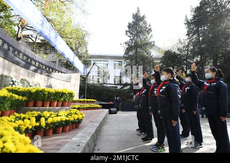 NANJING, CHINE - 13 DÉCEMBRE 2022 - les élèves du primaire saluent les jeunes pionniers au monument des victimes du massacre de Nanjing par le Japon Banque D'Images